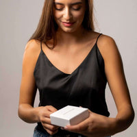 Thumbnail for Woman unboxing a Photo Projection Bracelet by Brother & Sisters, showcasing its elegant packaging.