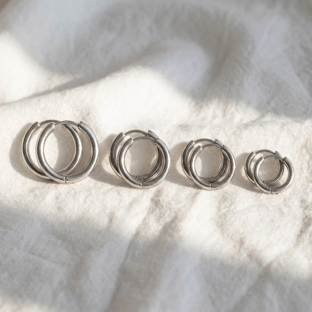 Huggie Hoop Earrings Set of 4 Pairs in Silver, macro detail of the metal and the finish | SKU: huggie-set-silver
