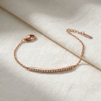 Thumbnail for Crystal Bar Bracelet en acier inoxydable 304L or rose, barre sertie de cristaux, pose a plat sur du lin