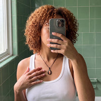 Thumbnail for Mirror selfie of a woman with curly red hair wearing the black secret drop photo necklace | SKU: TPH-DRPN-BLACK