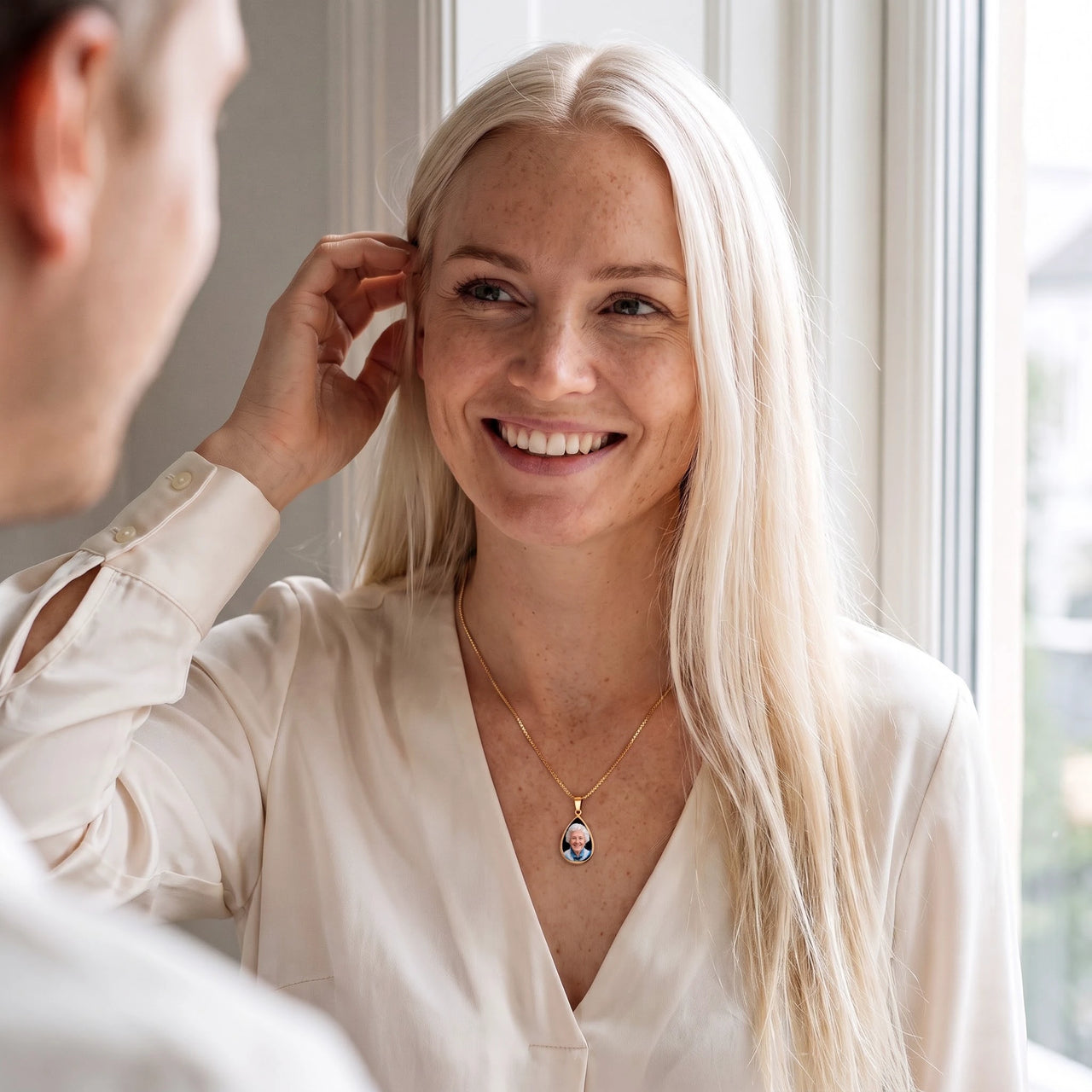 Blonde woman in a white blouse smiling, wearing the gold secret drop photo necklace | SKU: TPH-DRPN-GOLD