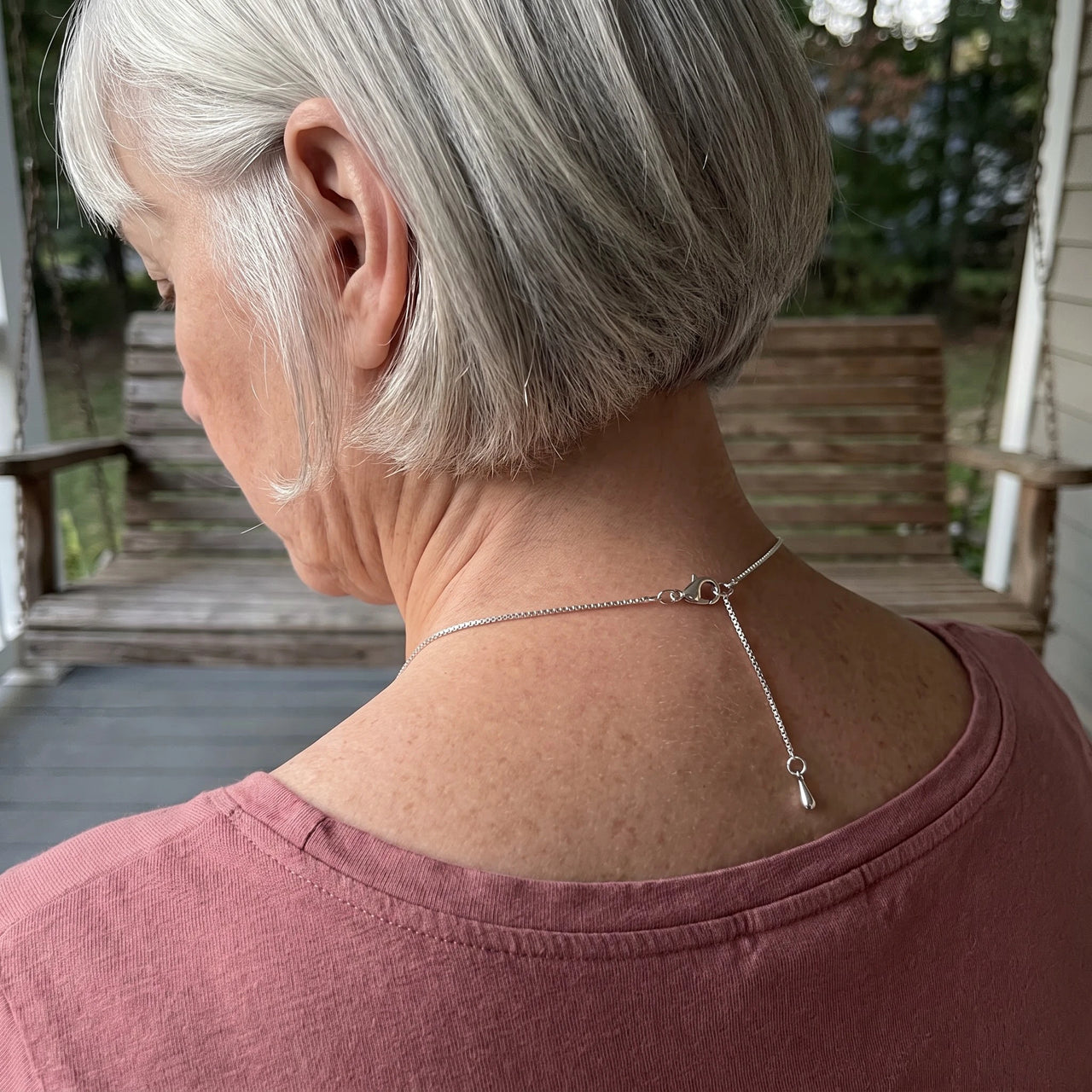 Back of the neck of a grey-haired woman showing the clasp and extension chain of the silver drop photo necklace | SKU: TPH-DRPN-SILVER