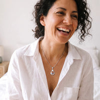 Thumbnail for Woman with curly hair laughing in a white shirt, wearing the silver secret drop photo necklace | SKU: TPH-DRPN-SILVER