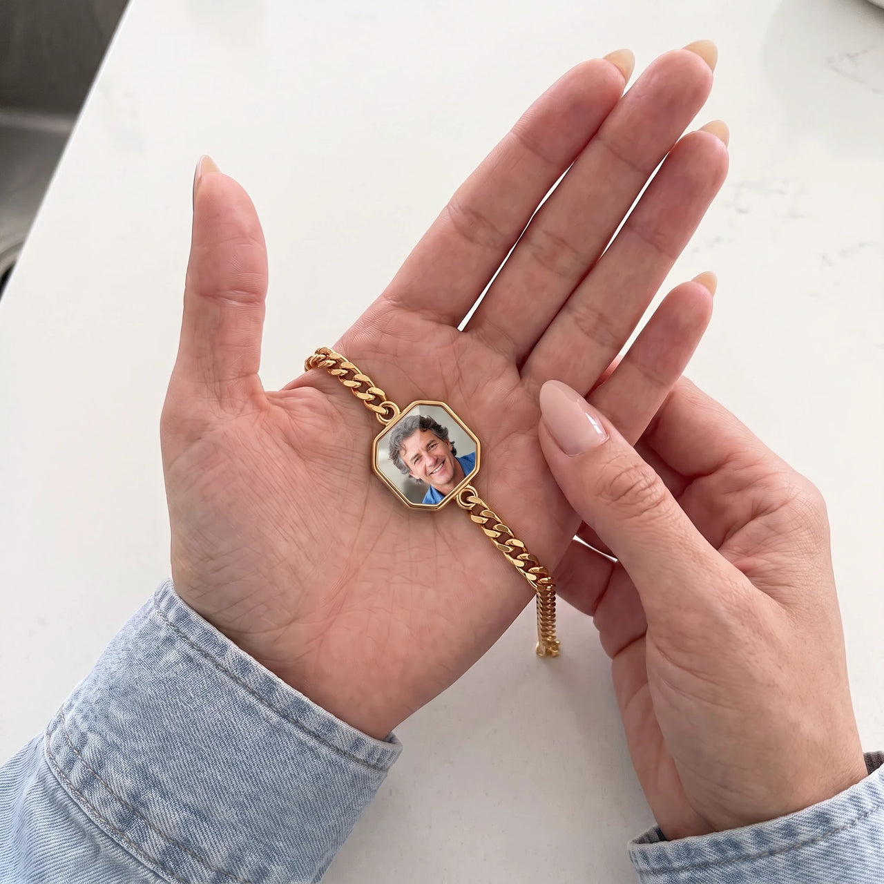 Thumb warming the gold octagon bracelet plate: the hidden photo appears under the thumb while the rest stays black | SKU: TPH-OCTB-GOLD-18