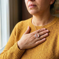 Thumbnail for Woman moved to tears, her hand on the rose gold round photo necklace holding a late loved one's photo | SKU: TPH-RNDN-ROSEGOLD